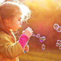 stock photo of child blowing bubbles