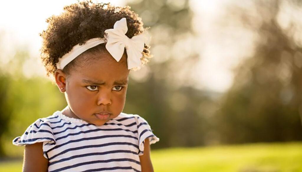 Little girl being disciplined pouting and looking sad.