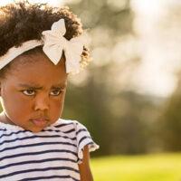 Little girl being disciplined pouting and looking sad.