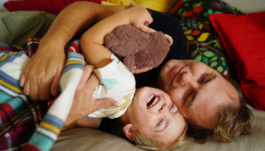 A,Joyful,Father,And,Young,Son,Cuddling,Together,On,A