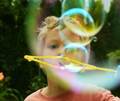 Curly-haired,Toddler,Boy,Releases,Even,Row,Of,Soap,Bubbles,From
