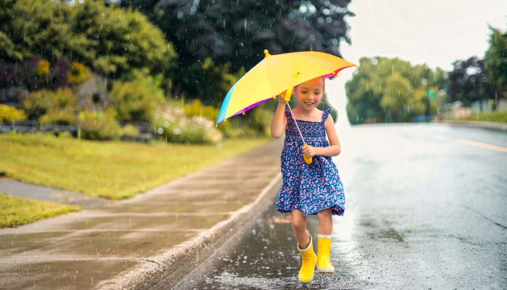 A,Happy,Funny,Child,With,Raincoat,Under,The,Summer,Raining