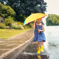 A,Happy,Funny,Child,With,Raincoat,Under,The,Summer,Raining